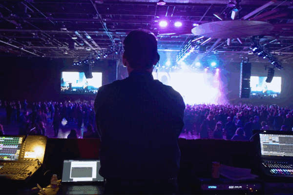 Person runs audio and visual production board at a concert