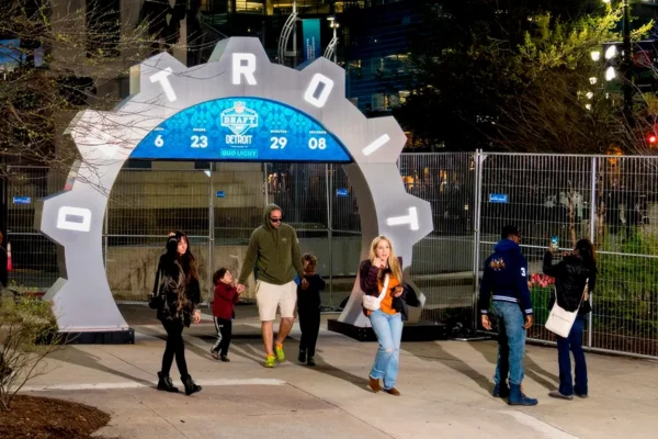 NFL Draft countdown clock arch at night in downtown Detroit with pedestrians walking underneath