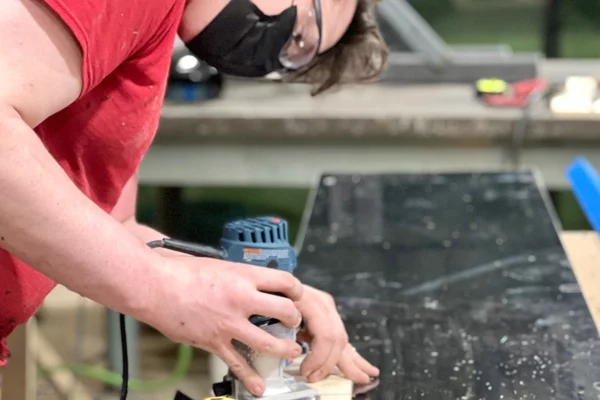 Fabricator using a router on a panel component during the build of the NFL Draft countdown clock