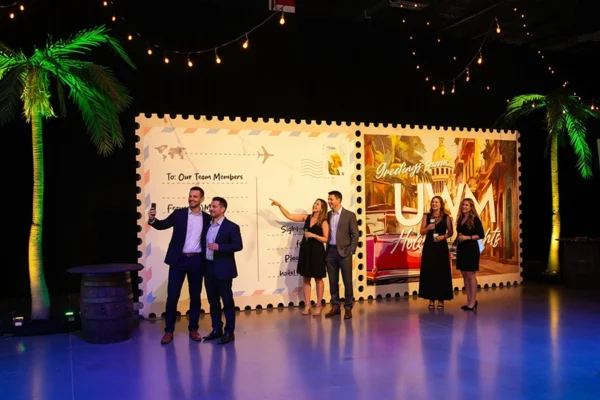 UWM holiday party guests posing in front of oversized postcard scenic