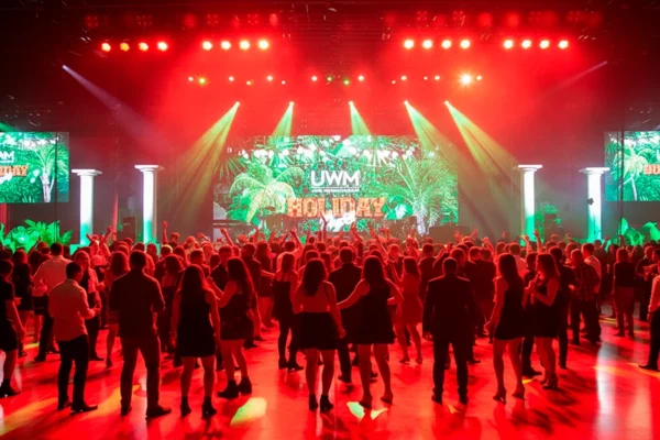 UWM Holiday stage with tropical theme and full crowd on dance floor