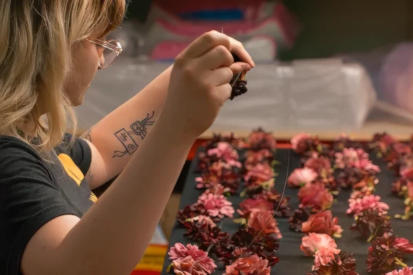 Building floral Crew member hand-placing flowers on Book Tower floral installation