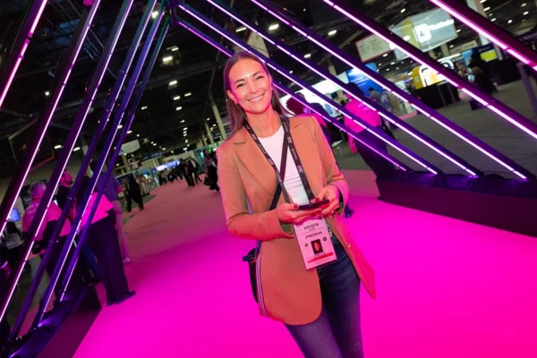 Attendee posing at Money 20/20 neon light installation