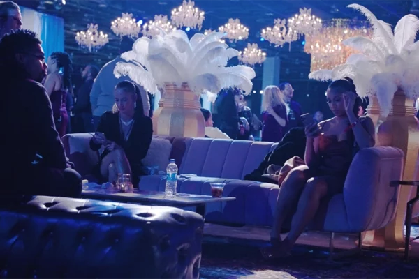 Guests relaxing in lounge seating beneath chandeliers at UWM holiday party