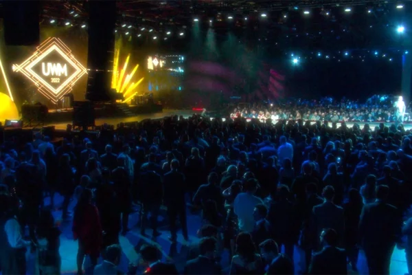 Large crowd at UWM 2022 holiday party with gold diamond stage design