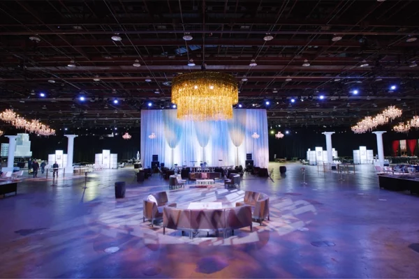 Grand ballroom setup for UWM holiday party with chandeliers and stage