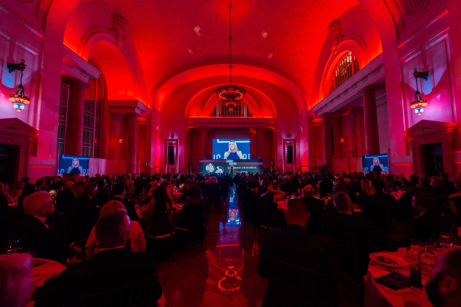 Full room shot of Automotive Hall of Fame gala with red ambient lighting