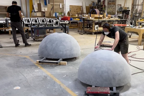 Display Group fabricators sanding dome shaped sculpture components in shop